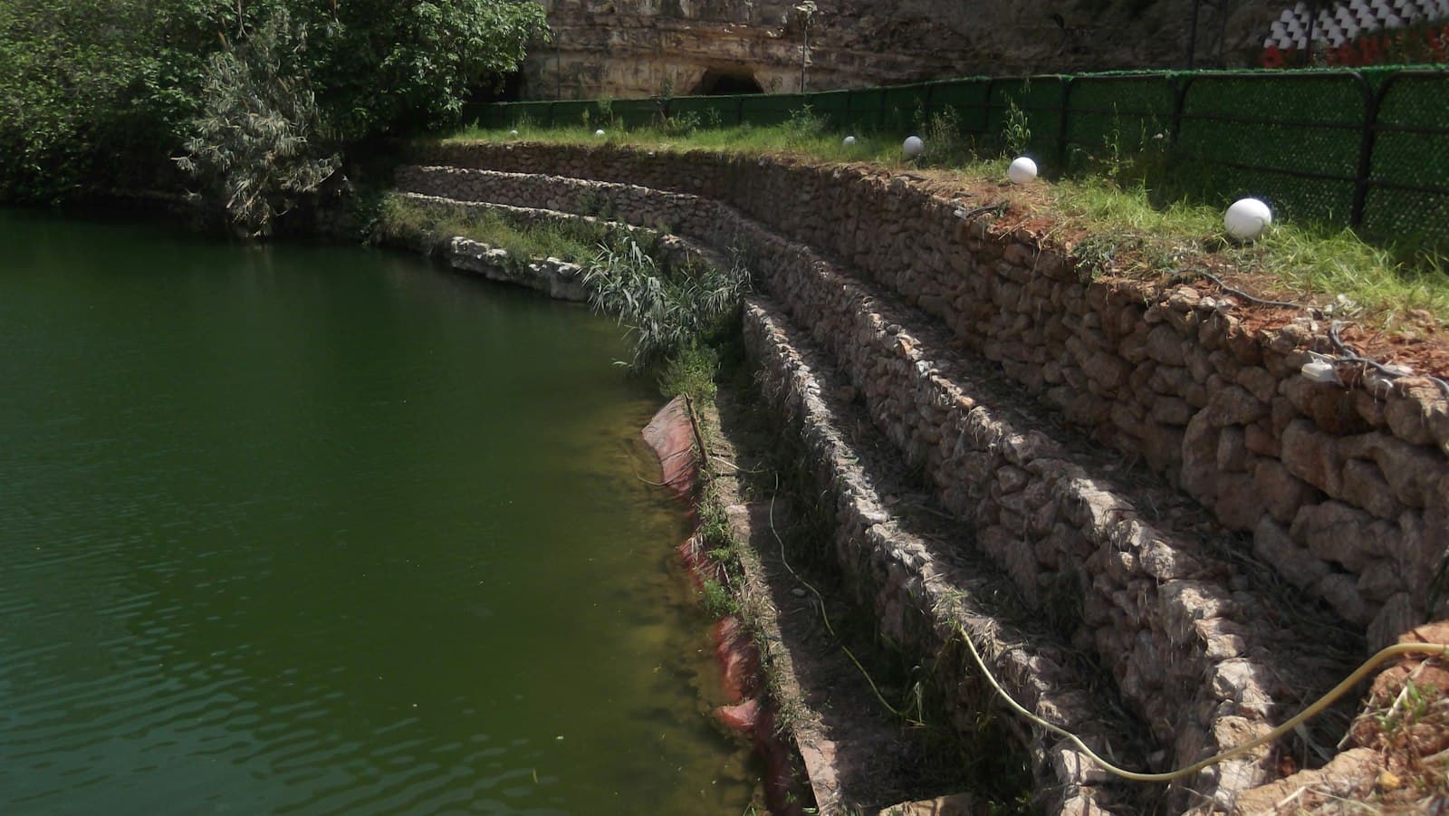 Terraced stone wall beside a pond